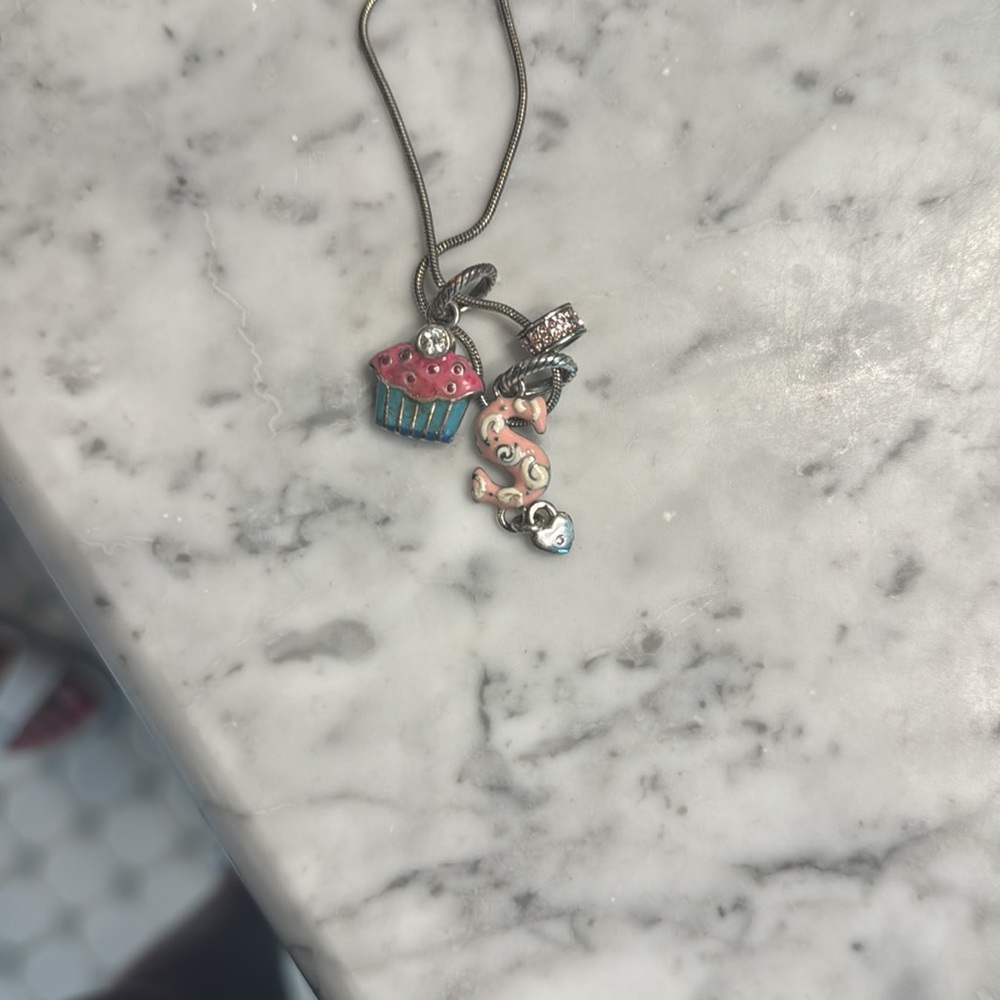 Brighton necklace charms include cupcake, S charm and pink jewel circle charm